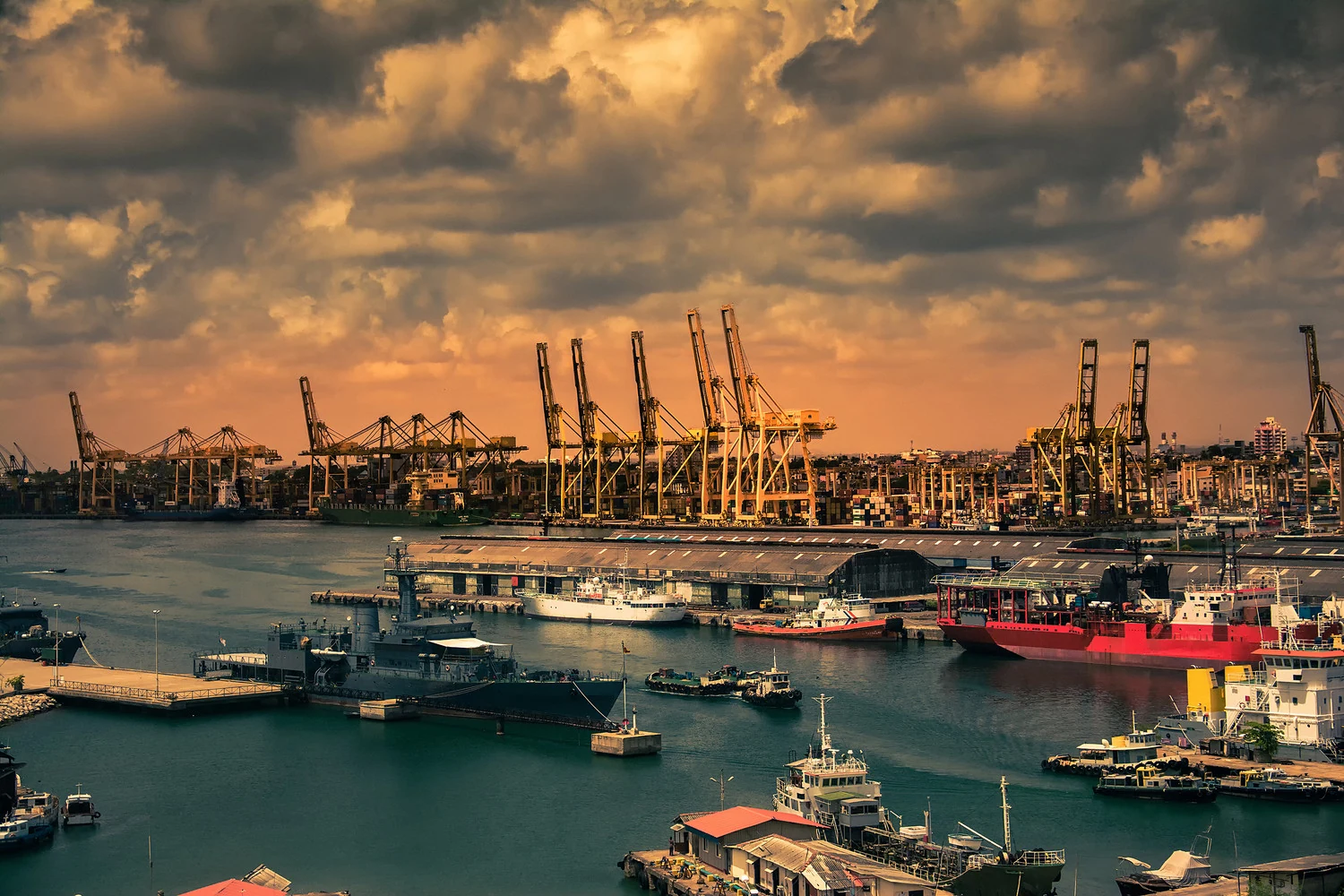 Cargo cranes, container operations and ships in a harbour at dusk